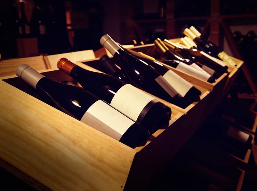 Weinkeller mit Weinflaschen liegend in Holzkästen 