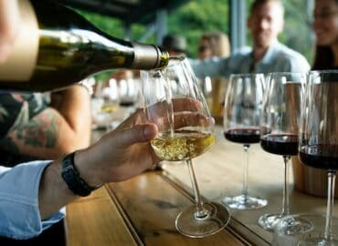 Weinprobe zu Hause: Weißwein wird eingeschenkt